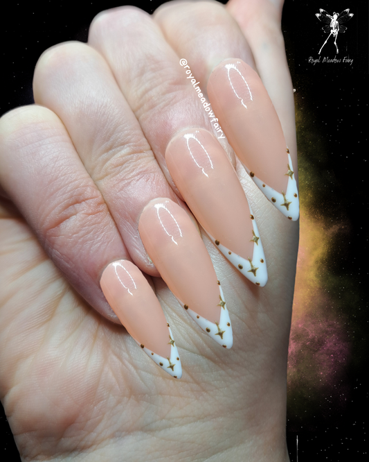nude and wite french tip press on nails with goldf nail art design of dots and stars