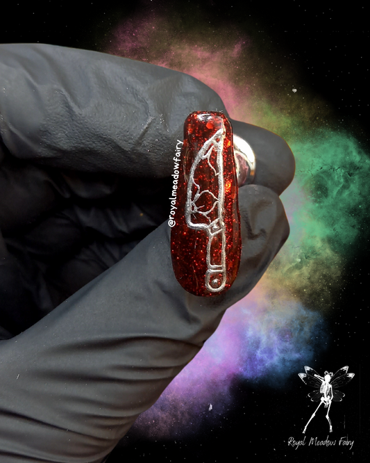 red glitter press on nail with a metallic silver tattoo style flower knife nail art design