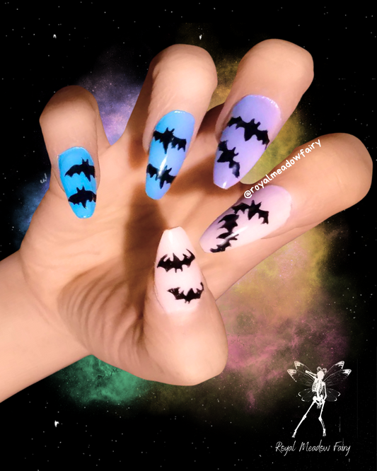 blue to purple and pink ombre stick-on fake nails with black bats nail art pastel goth design