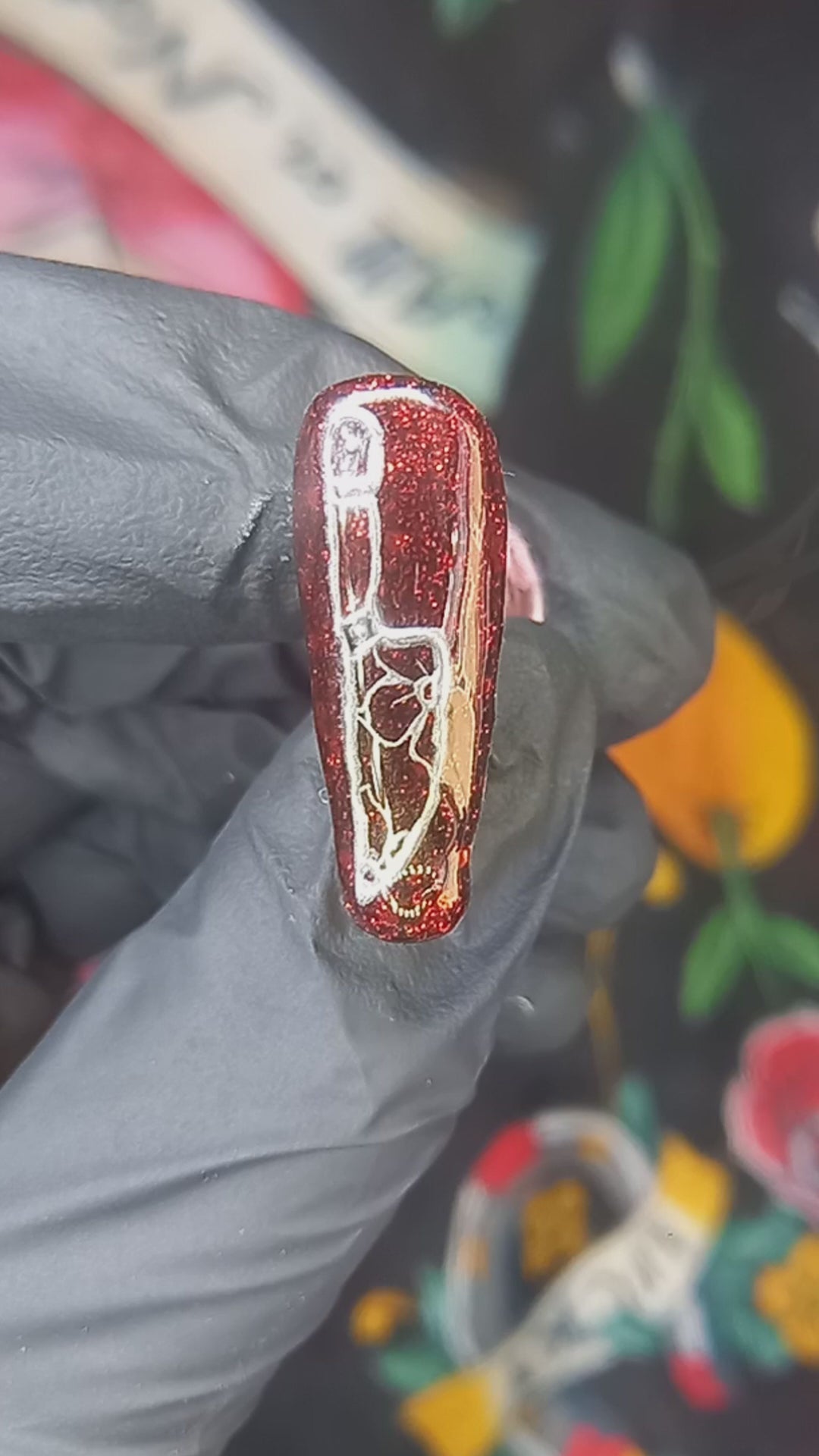 red glitter press on nails with silver nail art design of a traditional tattoo style knife with trad flowers