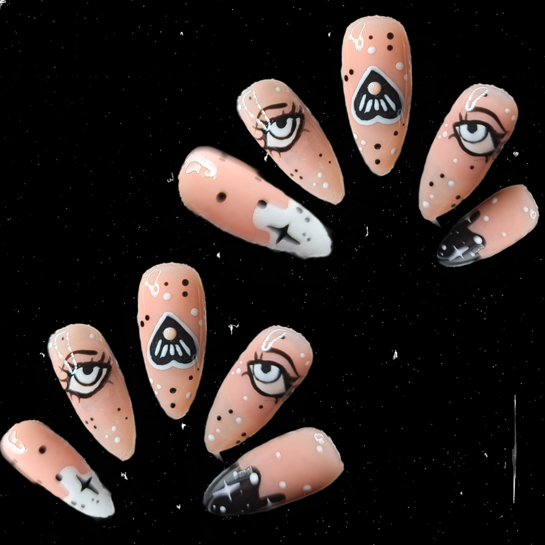 nude press on nail extensions with black and white planchette witchy eyes and star nail art nail art 