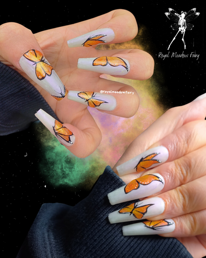 iridescent white and purple false nails with glitter orange butterfly nail art