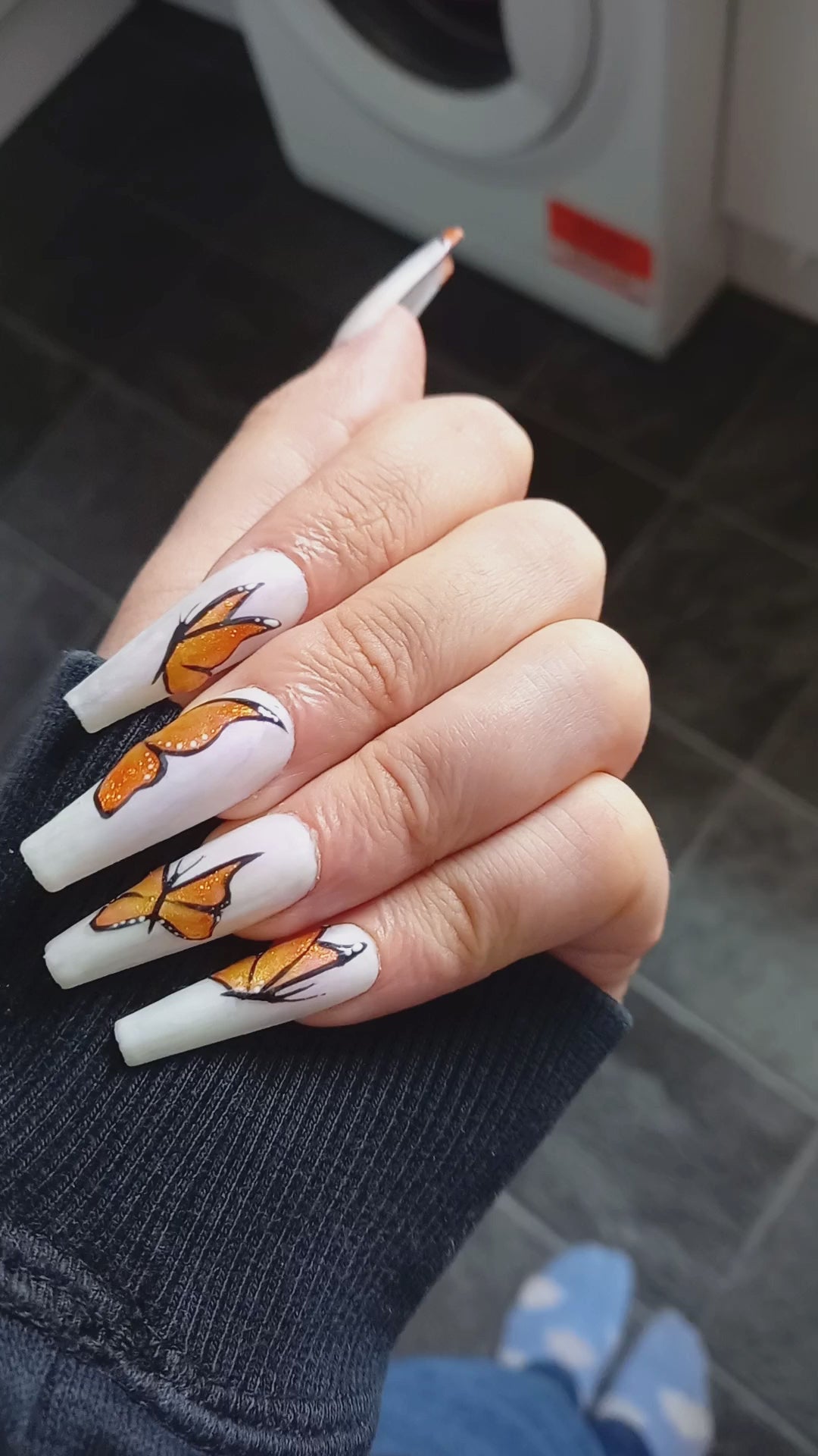 uks best press on nails. matte white with purple shimmer and orange glitter butterfly nail art design 